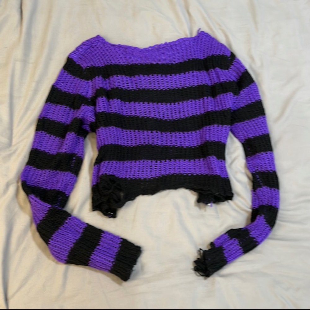 Woman’s striped purple and black sweater.